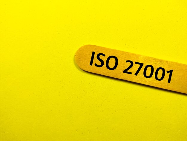 Business conceptText ISO 27001 writing on colored ice cream stick on a yellow background