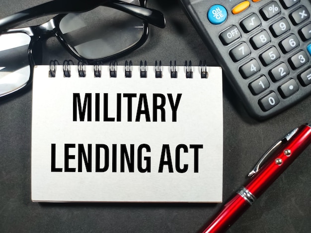 Business conceptText MILITARY LENDING ACT with pencalculator and glasses on black background