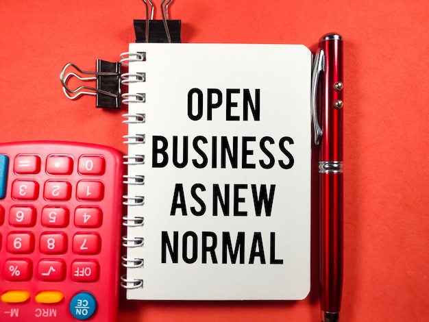 Business conceptText OPEN BUSINESS AS NEW NORMAL writing on notebook with penpaper clips