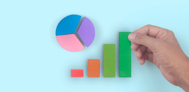 Business connecting piece of multi colored pie chart in a hand