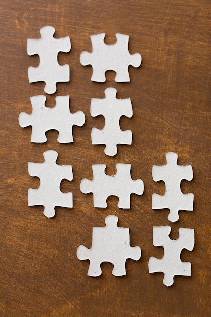 business and connection concept - close up of puzzle pieces on wooden surface