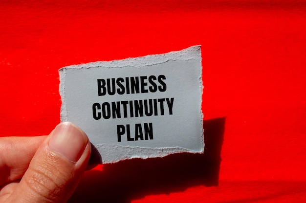 Photo business continuity plan message written on ripped paper piece with red background conceptual business continuity plan symbol copy space