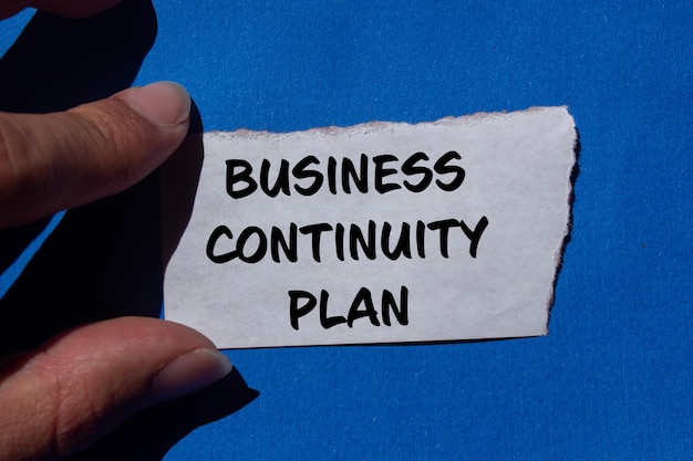 Photo business continuity plan message written on ripped torn paper with blue background conceptual business continuity plan symbol copy space