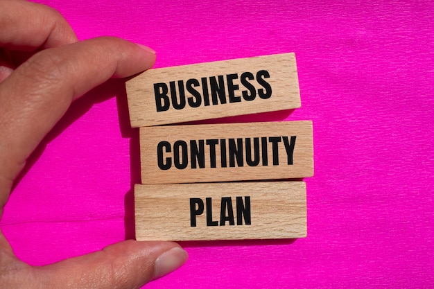 Photo business continuity plan message written on wooden blocks with pink background conceptual business continuity plan symbol copy space