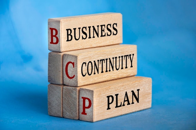 Business continuity plan text on wooden blocks with blue background Business recovery concept