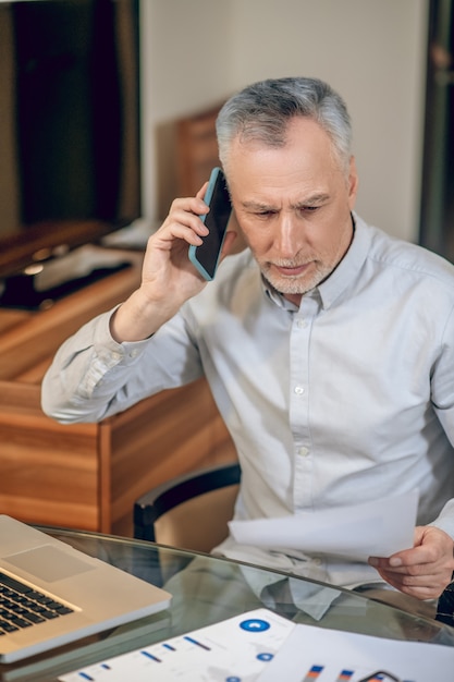 Business conversation. Mature man talking on the phone and looking involved