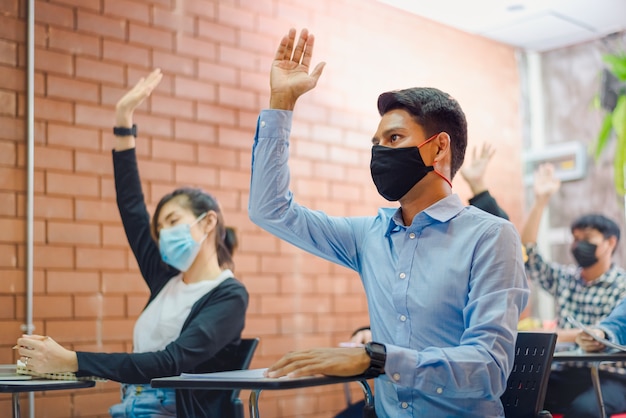 Business cooperation : Young asian male coach or speaker make flip chart presentation to diverse businesspeople at meeting in office. Male tutor or trainer present project to diverse colleagues.