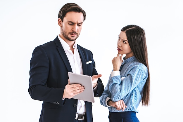 The business couple with a tablet standing on the white background