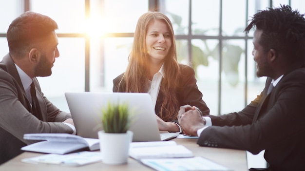 Business coworkers brainstorming negotiating on sales reports at table in meeting room