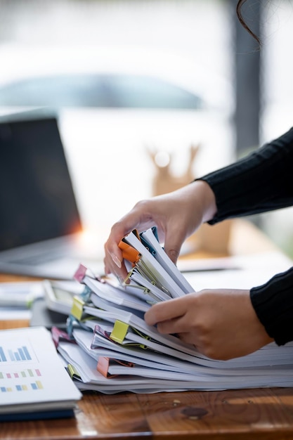 Business Documents concept woman hands working on Stacks paper files for checking document achieves on folders papers at office