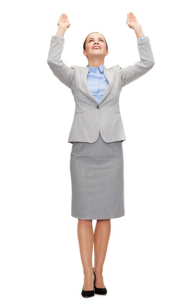 business and education concept - friendly young smiling businesswoman pushing up something imaginary