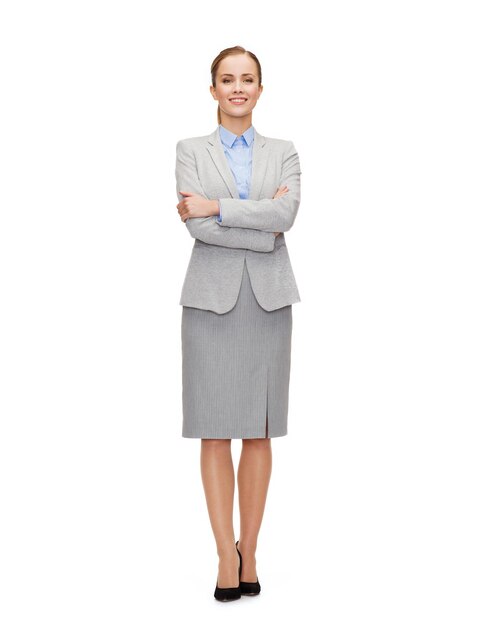 business and education concept - friendly young smiling businesswoman with crossed arms