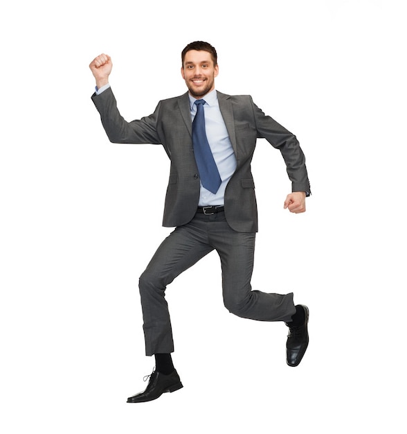 business and education concept - smiling businessman jumping