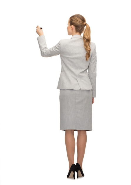 business, education and office concept - businesswoman or teacher with marker writing or drawing something imaginary from back