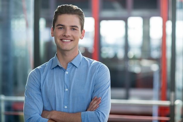 Business executive standing with arms crossed in office