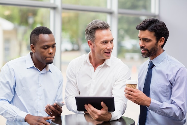 Business executives discussing over digital tablet