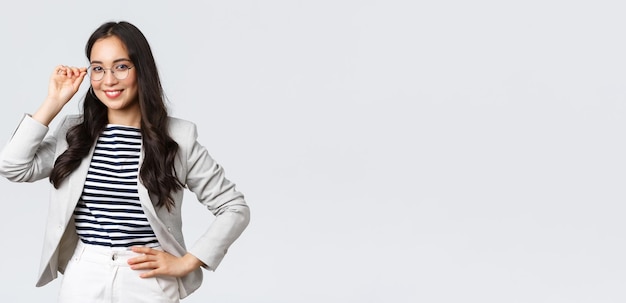 Business finance and employment female successful entrepreneurs concept Confident businesswoman in glasses and white suit ready for meeting smiling pleased standing determined