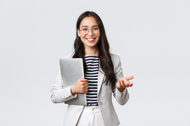 Business, finance and employment, female successful entrepreneurs concept. Smiling professional businesswoman, real estate broker showing clients good deal, carry laptop in hand