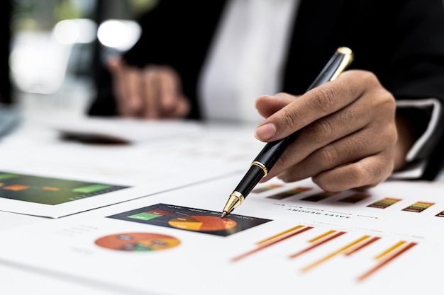 A business finance woman is reviewing a company's financial documents prepared by the Finance Department for a meeting with business partners. Concept of validating the accuracy of financial numbers.