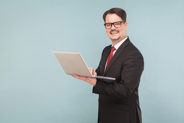 Business, gadgets,technologies. Man working in lap top. Indoor, studio shot, isolated on light blue or gray background