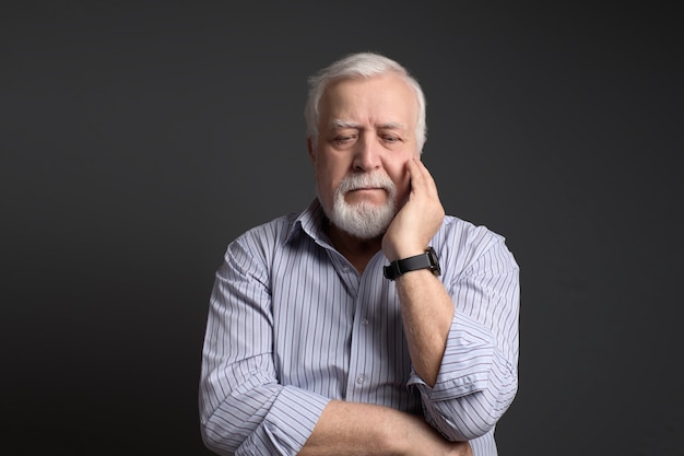 Business-haired man looks thoughtfully and holding his head