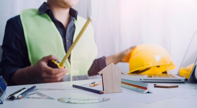 Business hand working and laptop with on on architectural project at construction site at office desk in office