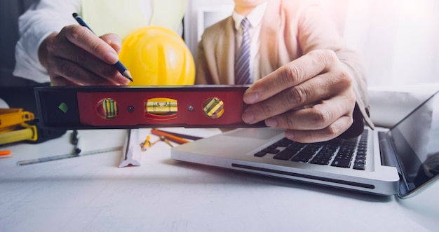 Business hand working and laptop with on on architectural project at construction site at office desk in office