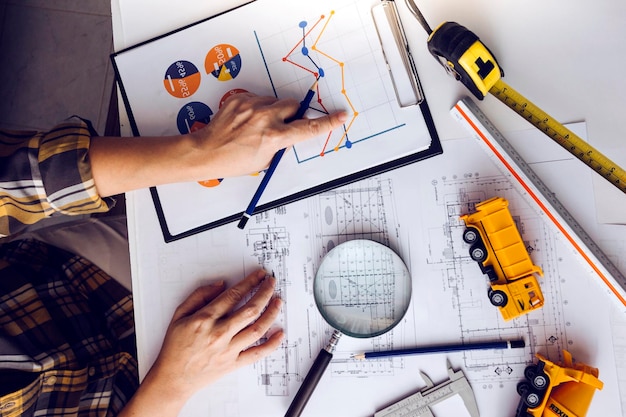 Business hand working and laptop with on on architectural project at construction site at office desk in office