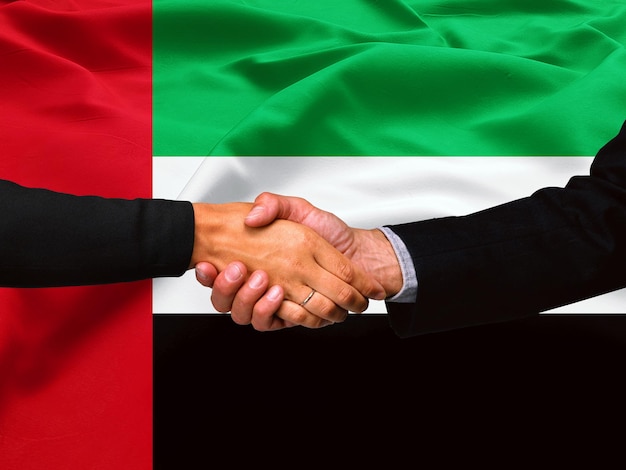 Business handshake on United Arab Emirates flag background