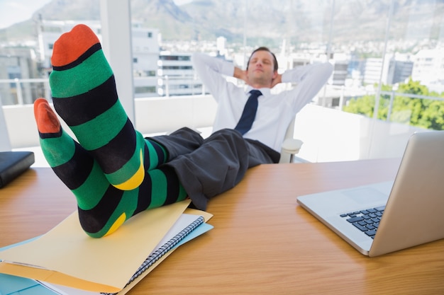 Business having a nap with feet on his desk