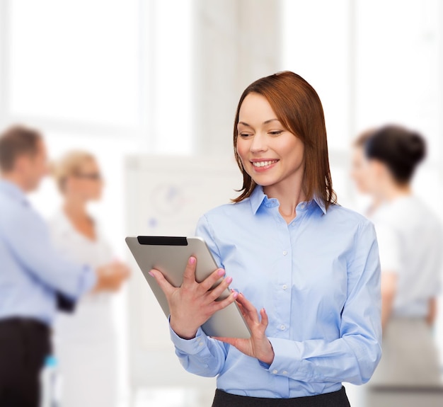 business, internet and technology concept - smiling woman looking at tablet pc computer at office