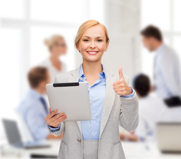 business, internet and technology concept - smiling woman with tablet pc computer showing thumbs up at office