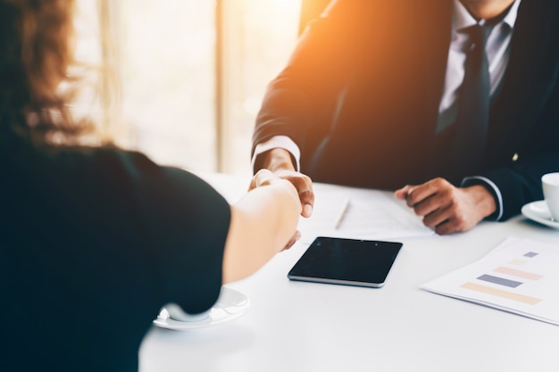 Business interview concept - Businessman and woman making handshake in office