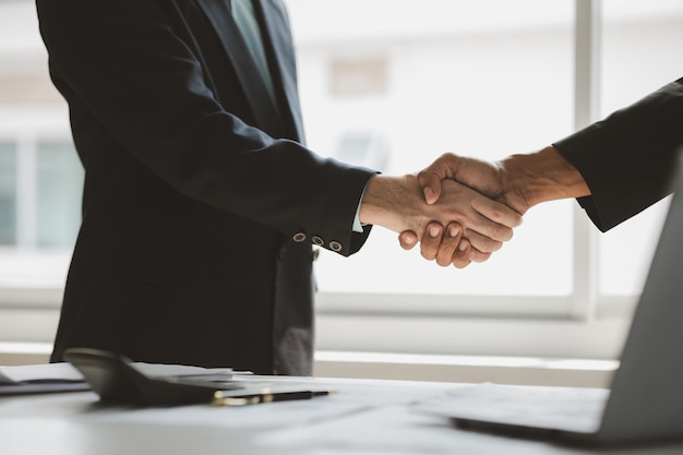 Business investor group holding hands Two businessmen are agreeing on business together and shaking hands after a successful negotiation Handshaking is a Western greeting or congratulation