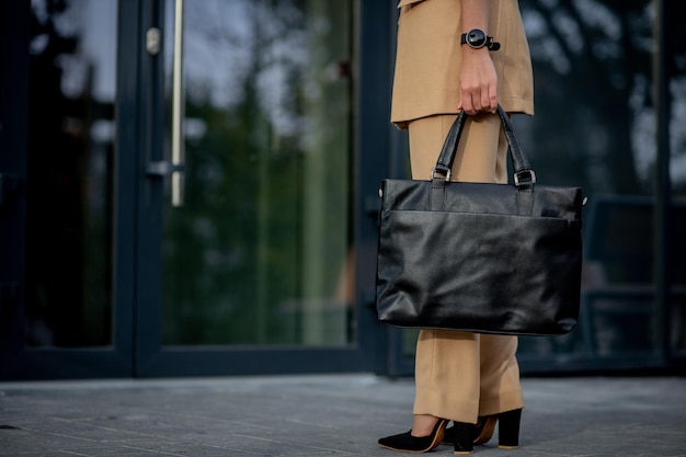 Business lady holding a laptop bag going to the office Display of businesswoman on modern buildings in the city