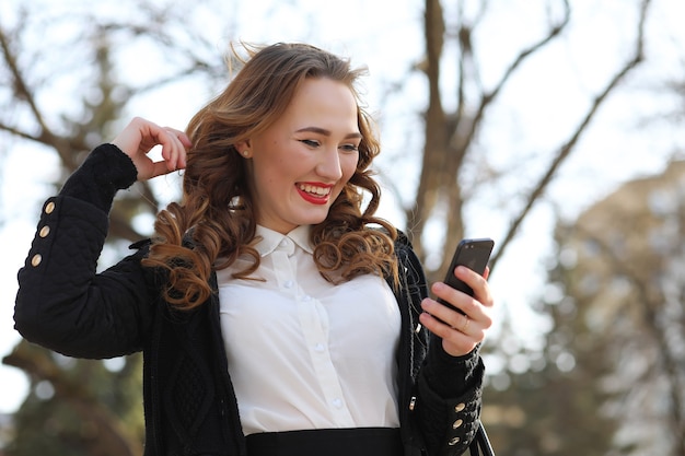 Business lady in a suit outdoors with a mobile phone