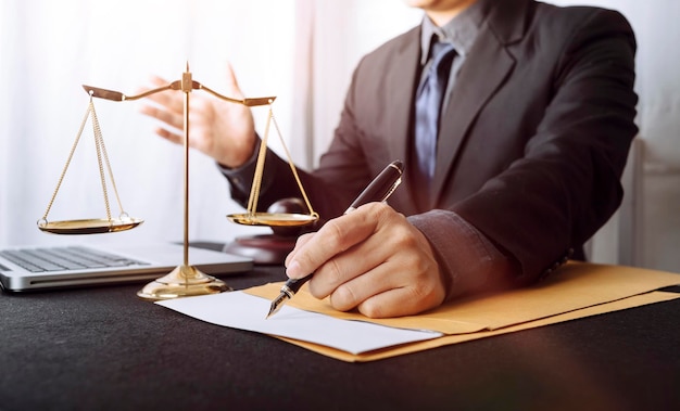 Business and lawyers discussing contract papers with brass scale on desk in office Law legal services advice justice and law concept picture with film grain effect