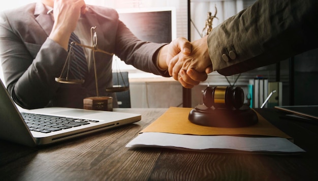 Business and lawyers discussing contract papers with brass scale on desk in office Law legal services advice justice and law concept picture with film grain effect