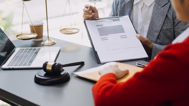 Business and lawyers discussing contract papers with brass scale on desk in office Law legal services advice justice and law concept picture with film grain effect