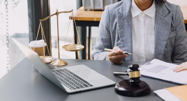 Business and lawyers discussing contract papers with brass scale on desk in office Law legal services advice justice and law concept picture with film grain effect