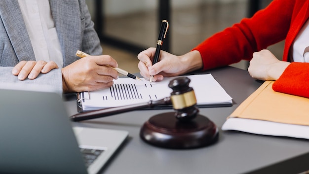 Business and lawyers discussing contract papers with brass scale on desk in office Law legal services advice justice and law concept picture with film grain effect