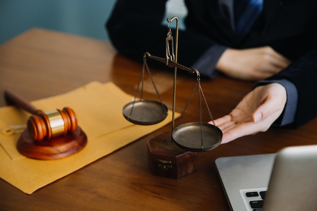 Business and lawyers discussing contract papers with brass scale on desk in office Law legal services advice justice and law concept picture with film grain effect