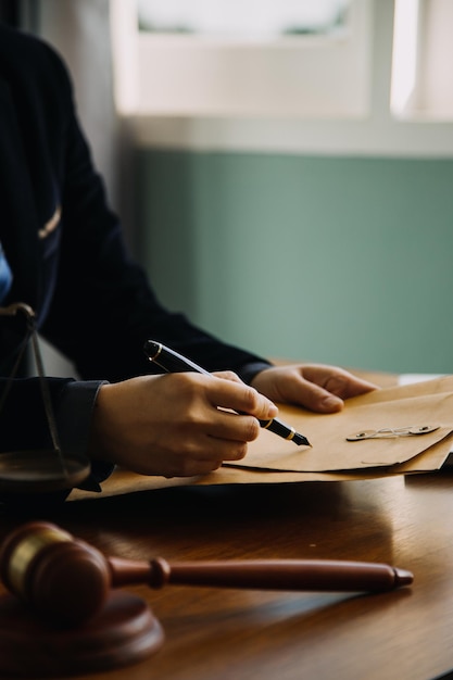 Business and lawyers discussing contract papers with brass scale on desk in office Law legal services advice justice and law concept picture with film grain effect