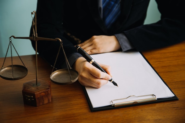 Business and lawyers discussing contract papers with brass scale on desk in office Law legal services advice justice and law concept picture with film grain effect