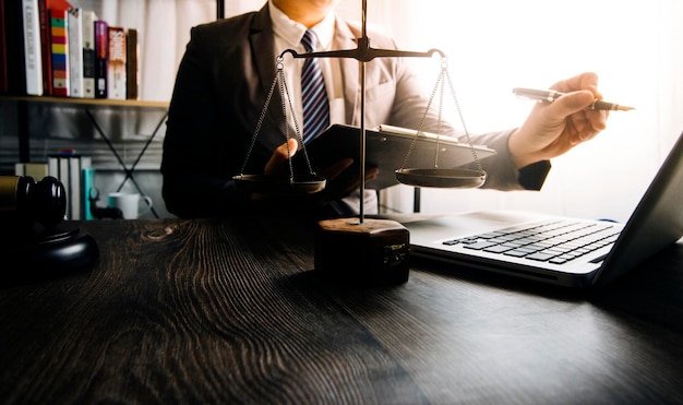 Business and lawyers discussing contract papers with brass scale on desk in office Law legal services advice justice and law concept picture with film grain effect