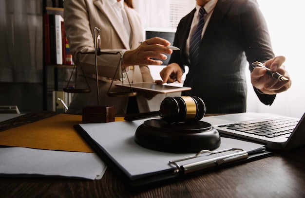 Business and lawyers discussing contract papers with brass scale on desk in office Law legal services advice justice and law concept picture with film grain effect