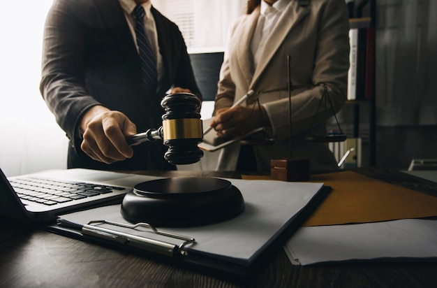 Business and lawyers discussing contract papers with brass scale on desk in office Law legal services advice justice and law concept picture with film grain effect