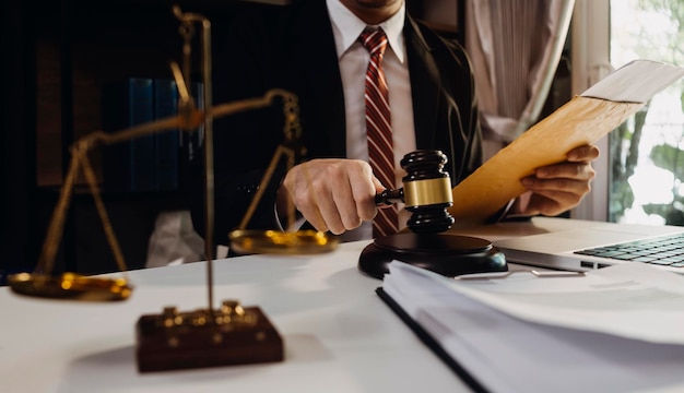 Business and lawyers discussing contract papers with brass scale on desk in office Law legal services advice justice and law concept picture with film grain effect