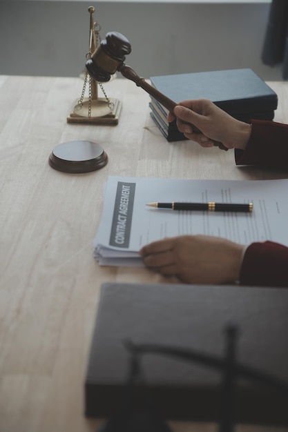 Business and lawyers discussing contract papers with brass scale on desk in office Law legal services advice justice and law concept picture with film grain effect