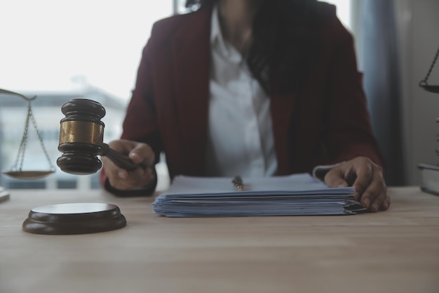 Business and lawyers discussing contract papers with brass scale on desk in office Law legal services advice justice and law concept picture with film grain effect